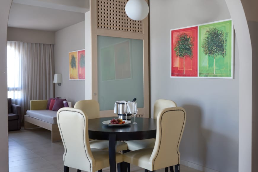 a dining room table with a white couch and a green wall