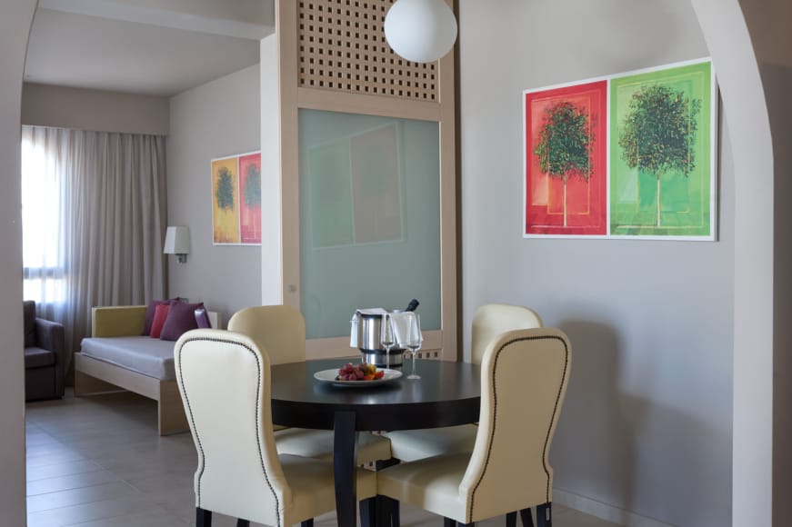 a dining room table with a white couch and a green wall