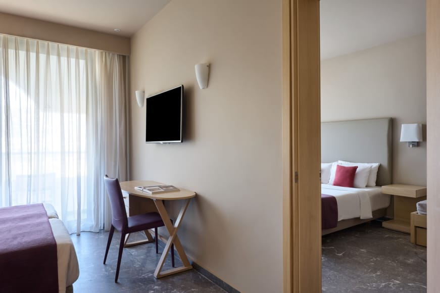 a room with a bed desk and a television