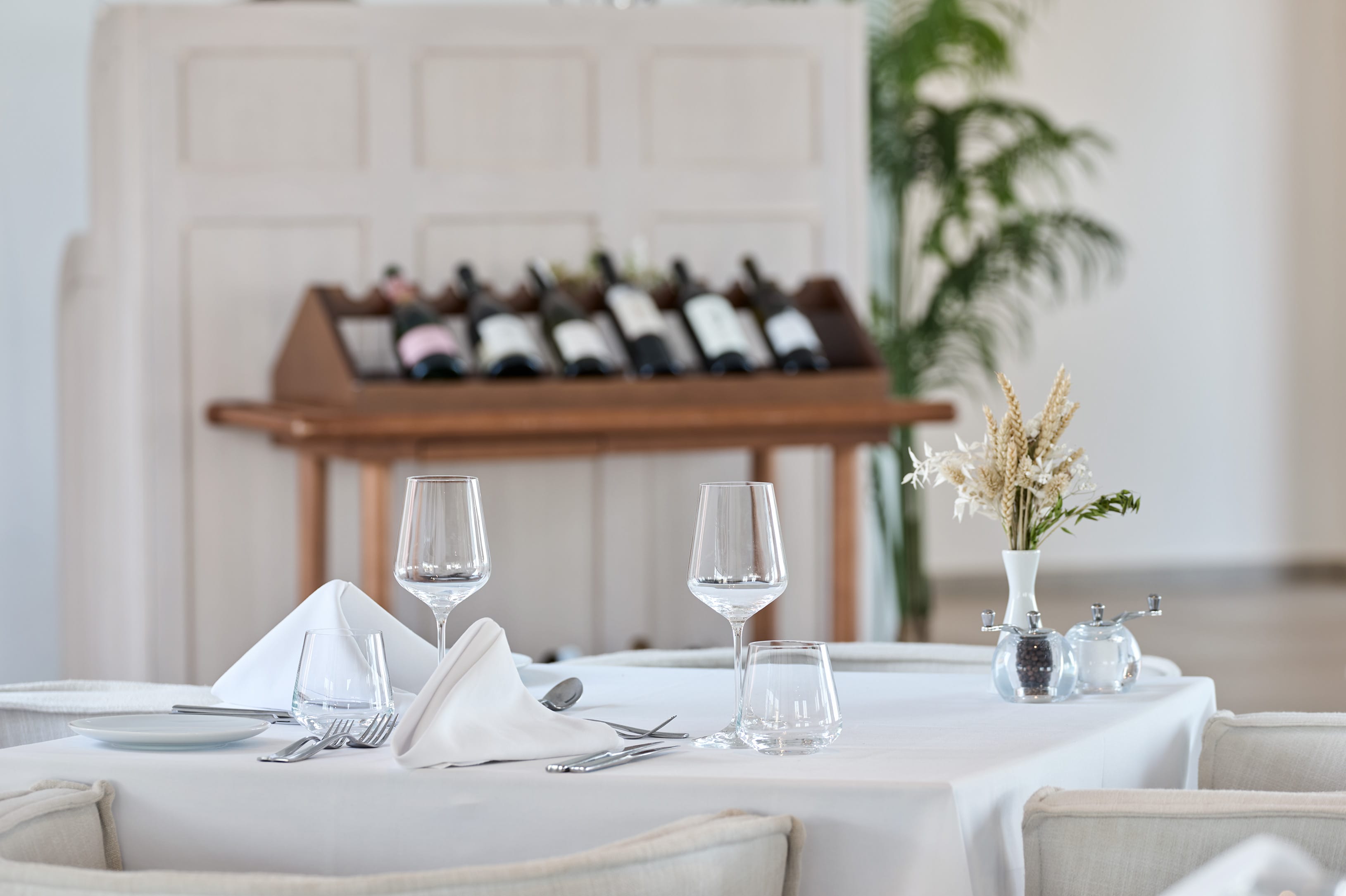 a table with glasses and a vase with flowers on it