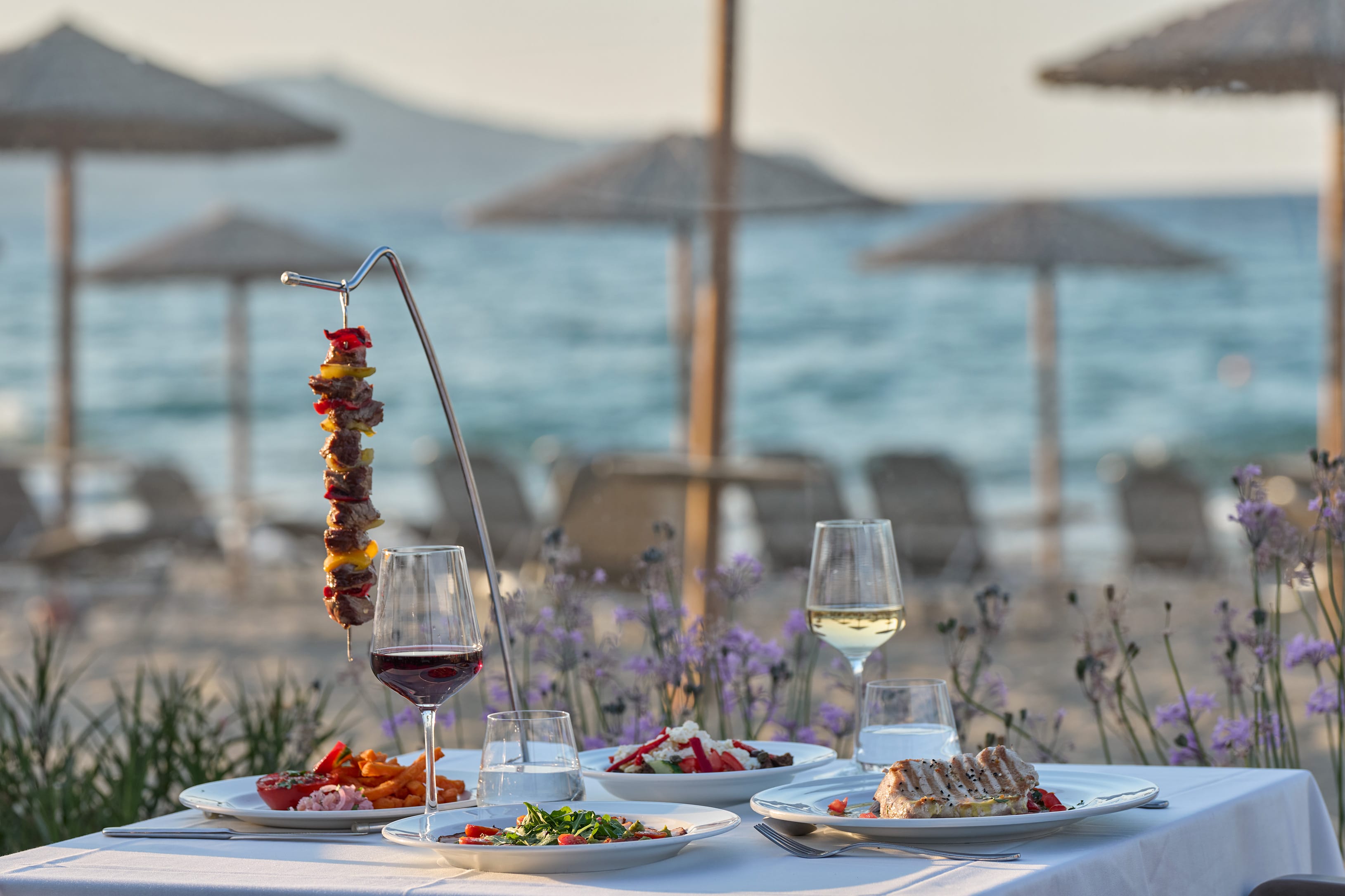 a table with food and drinks on it by the water