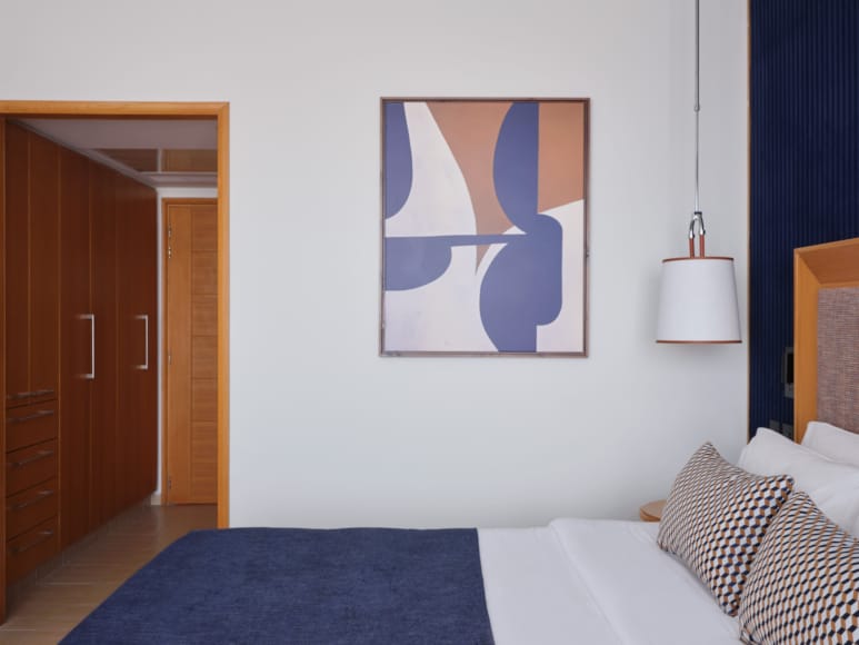 a bedroom with a painting on the wall