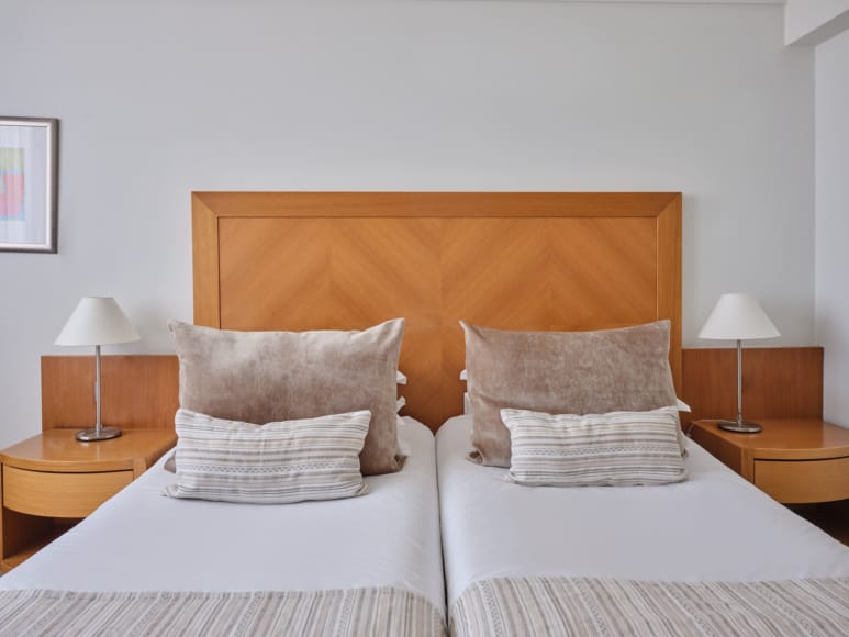 a bed with pillows and lamps