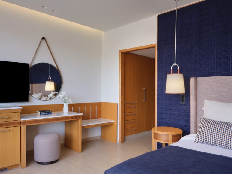 a bedroom with a bed desk and a mirror