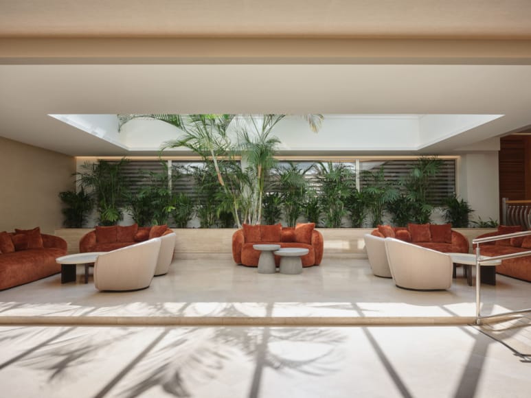 a room with a large pool table and chairs and a large window