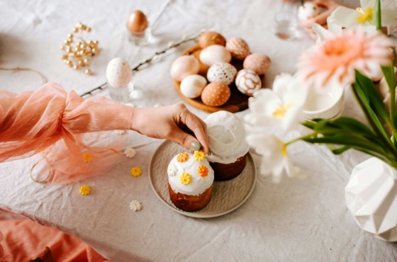 a hand reaching for cupcakes