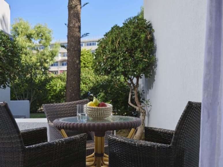 a table with chairs and a basket on it by a window