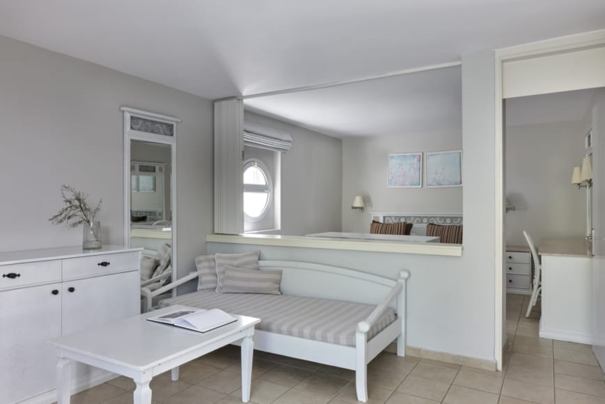 a large white bedroom with a large mirror