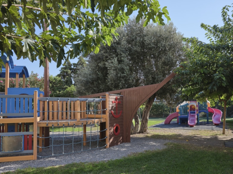 a playground with trees and a slide