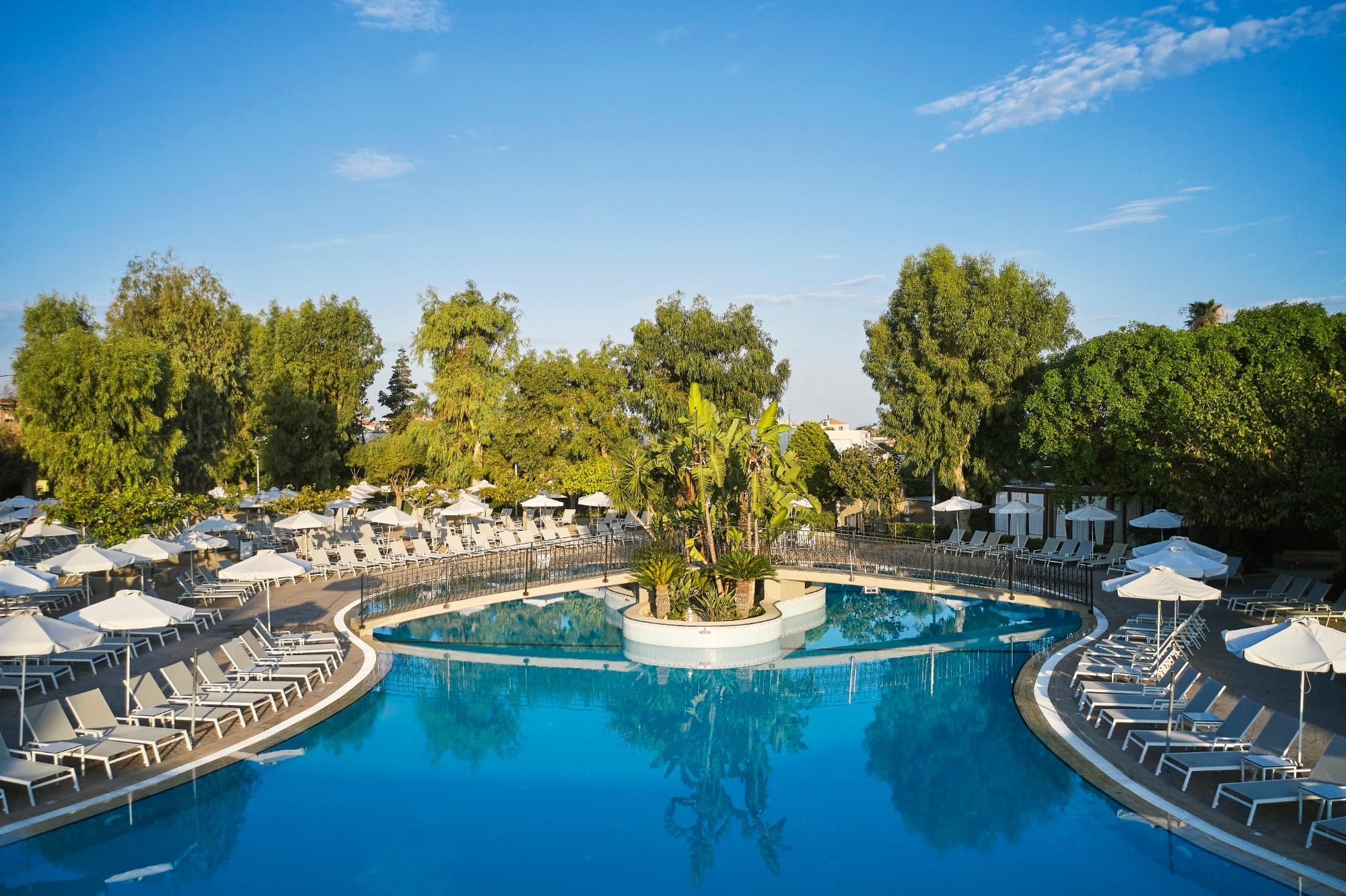 a pool with umbrellas and trees around it