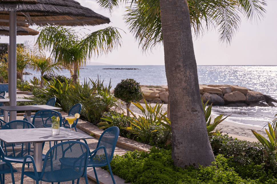 a table and chairs next to a beach