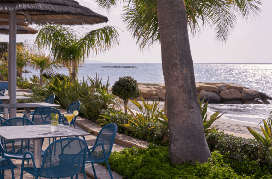 a table and chairs next to a beach