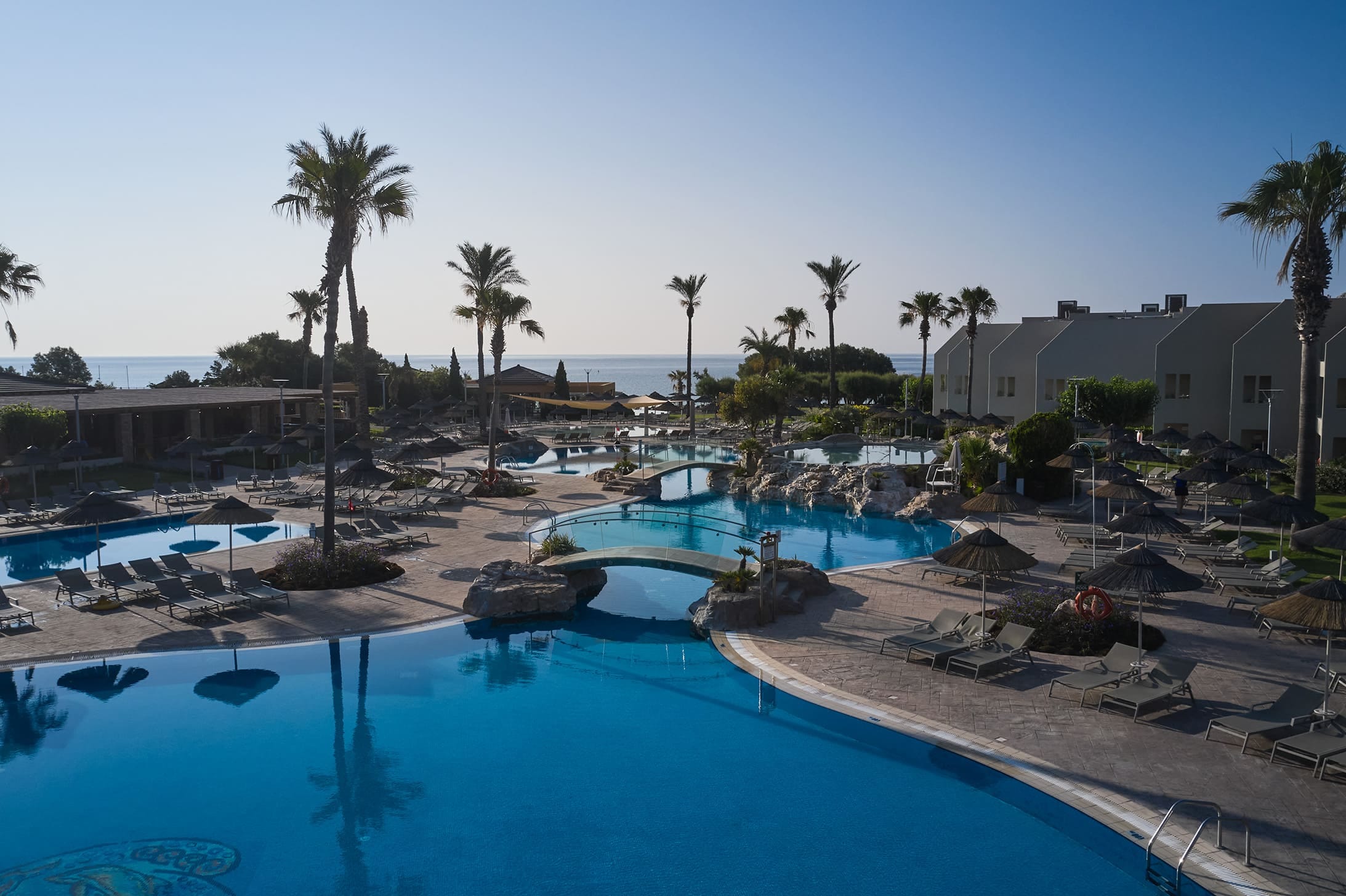 a pool with a beach and palm trees