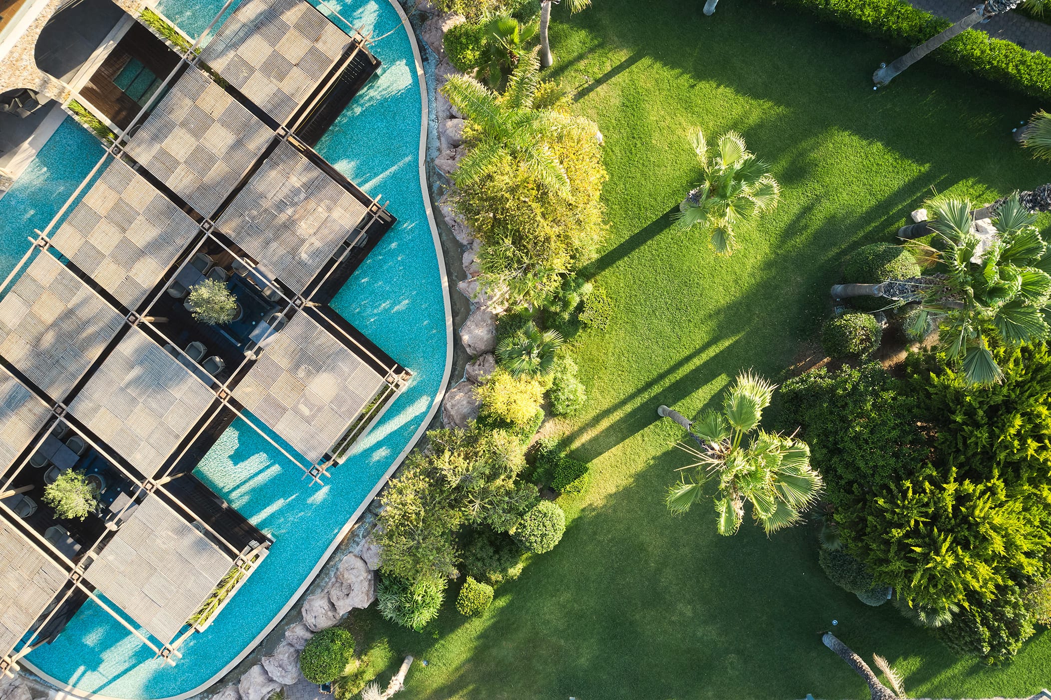 a building with a pool and trees around it