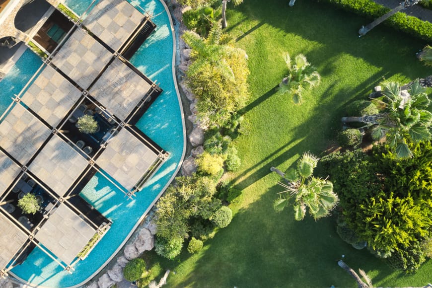 a building with a pool and trees around it