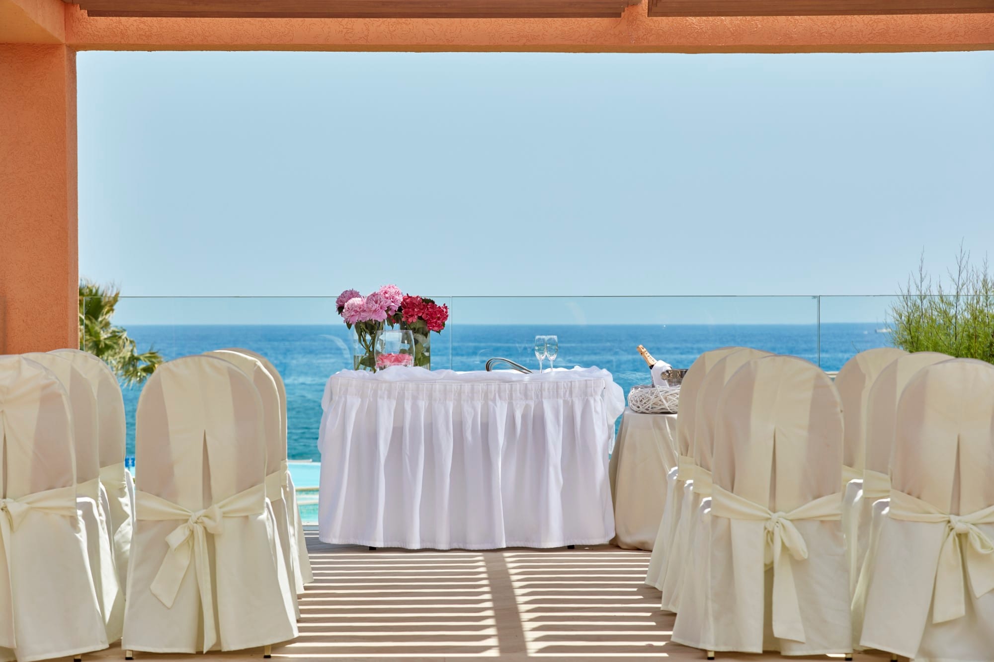a table set with chairs and a view of the ocean