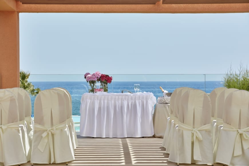 a table set with chairs and a view of the ocean