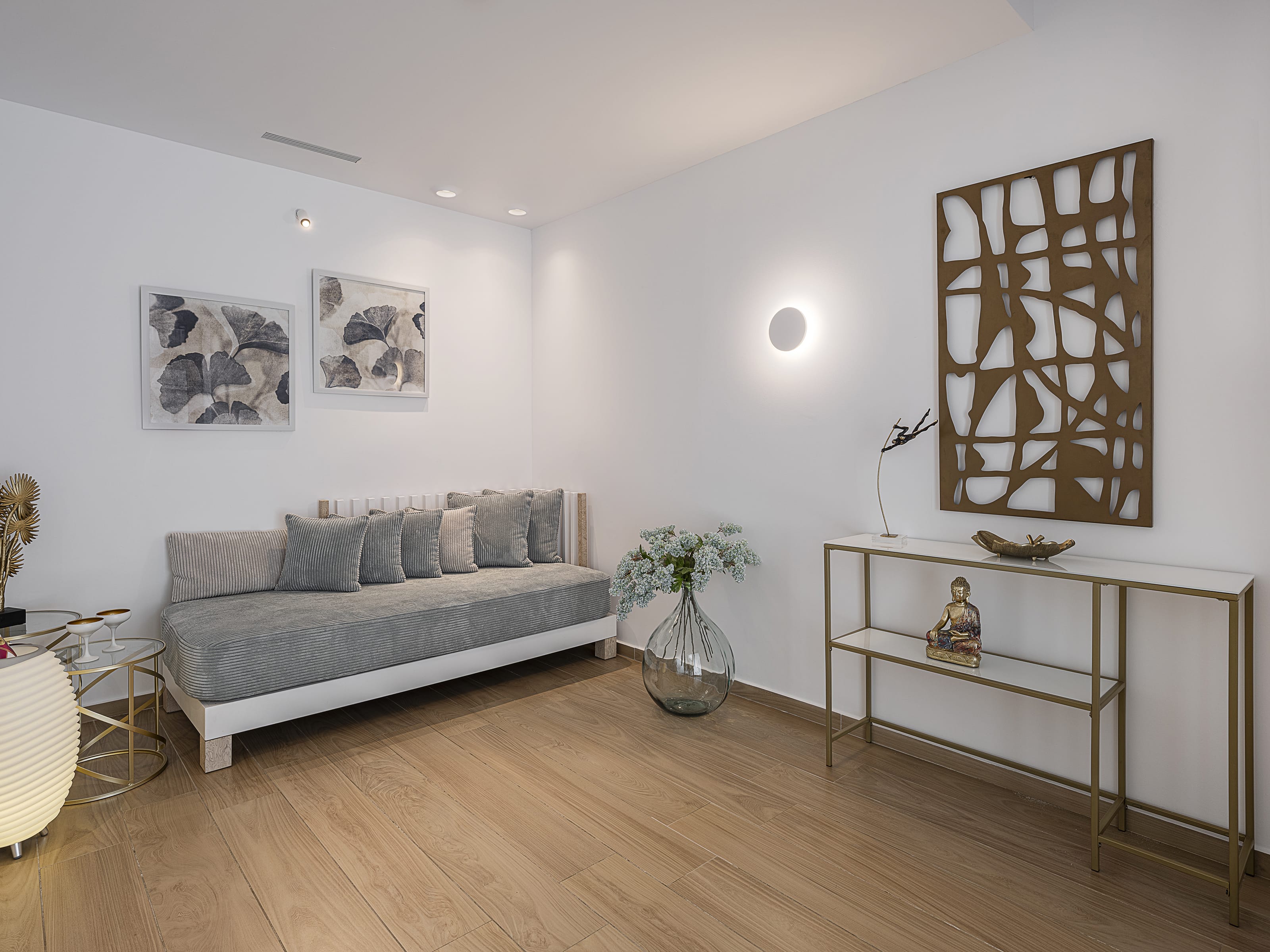 a room with a couch and a table with a plant on it