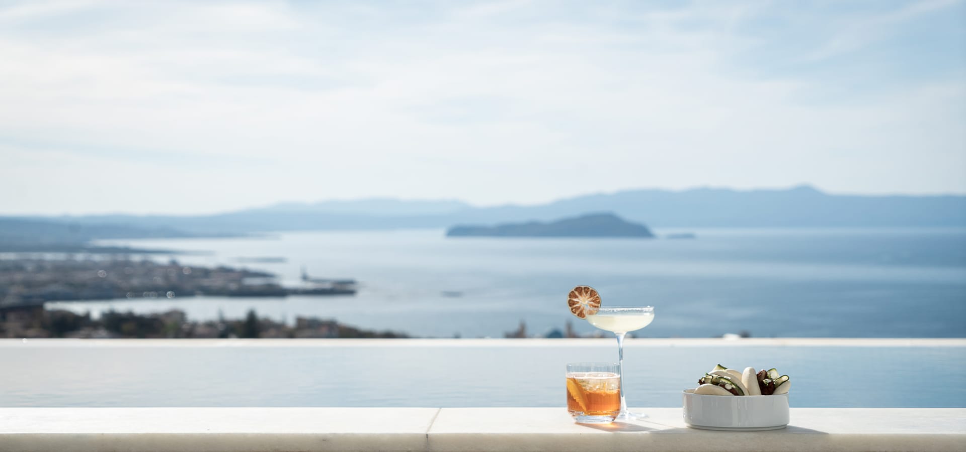 a person sitting at a table with a glass of liquid and a plate of food