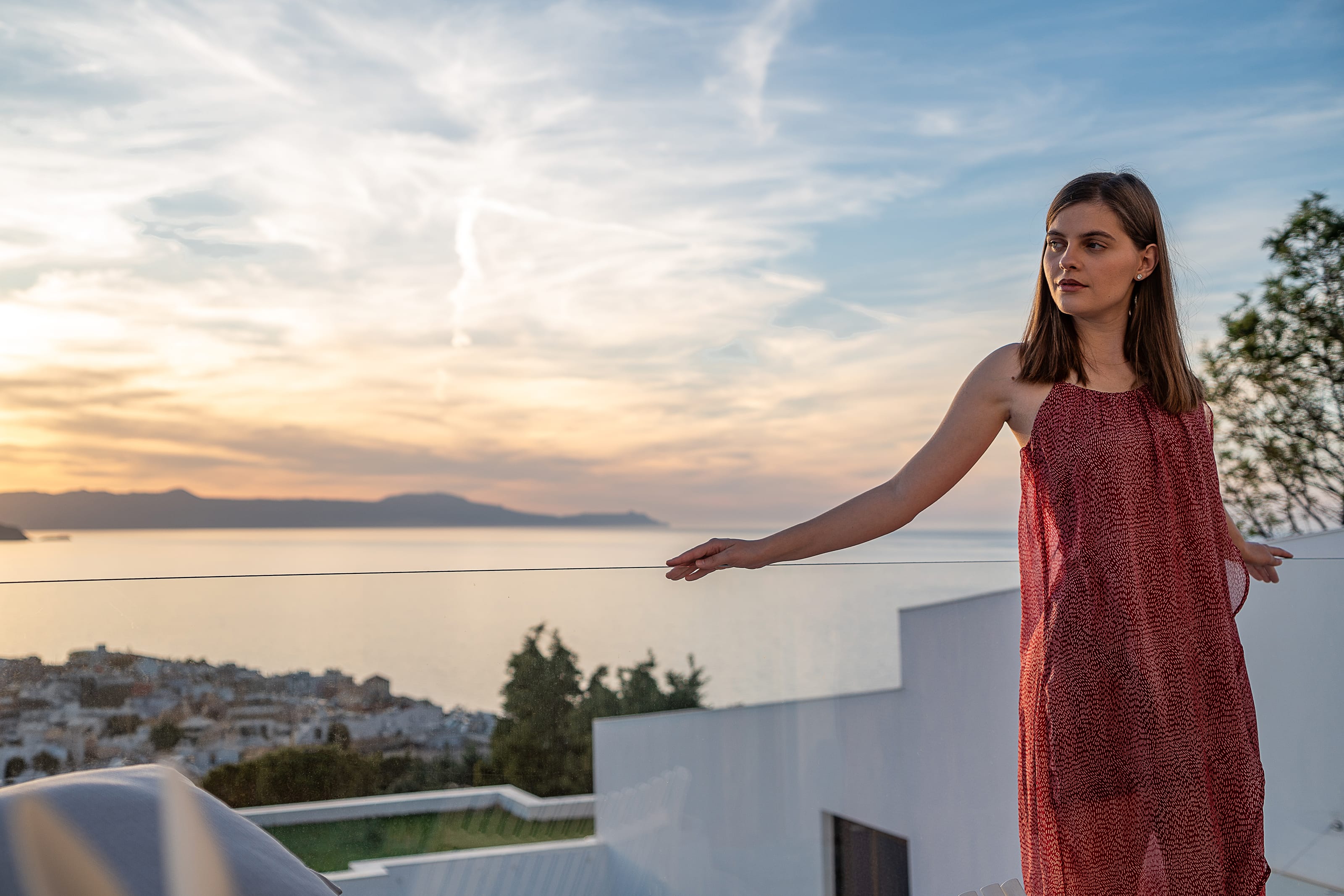 a person in a red dress standing on a balcony