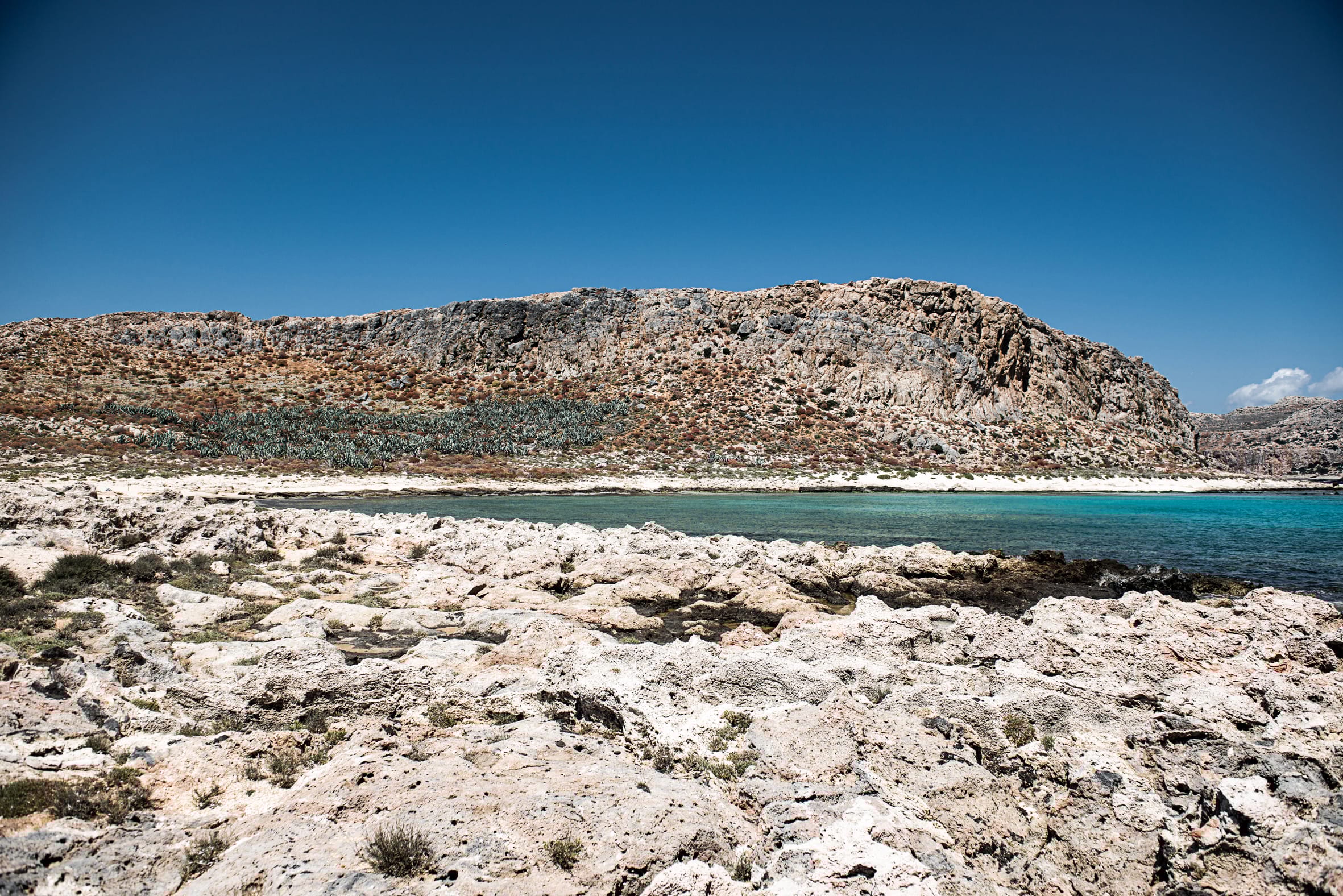 a body of water with a hill in the background