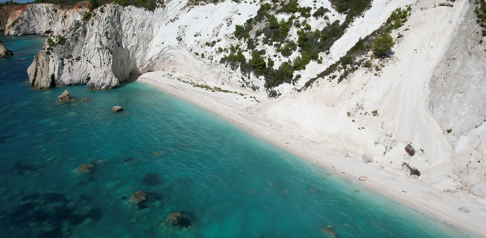a body of water with snow and trees around it