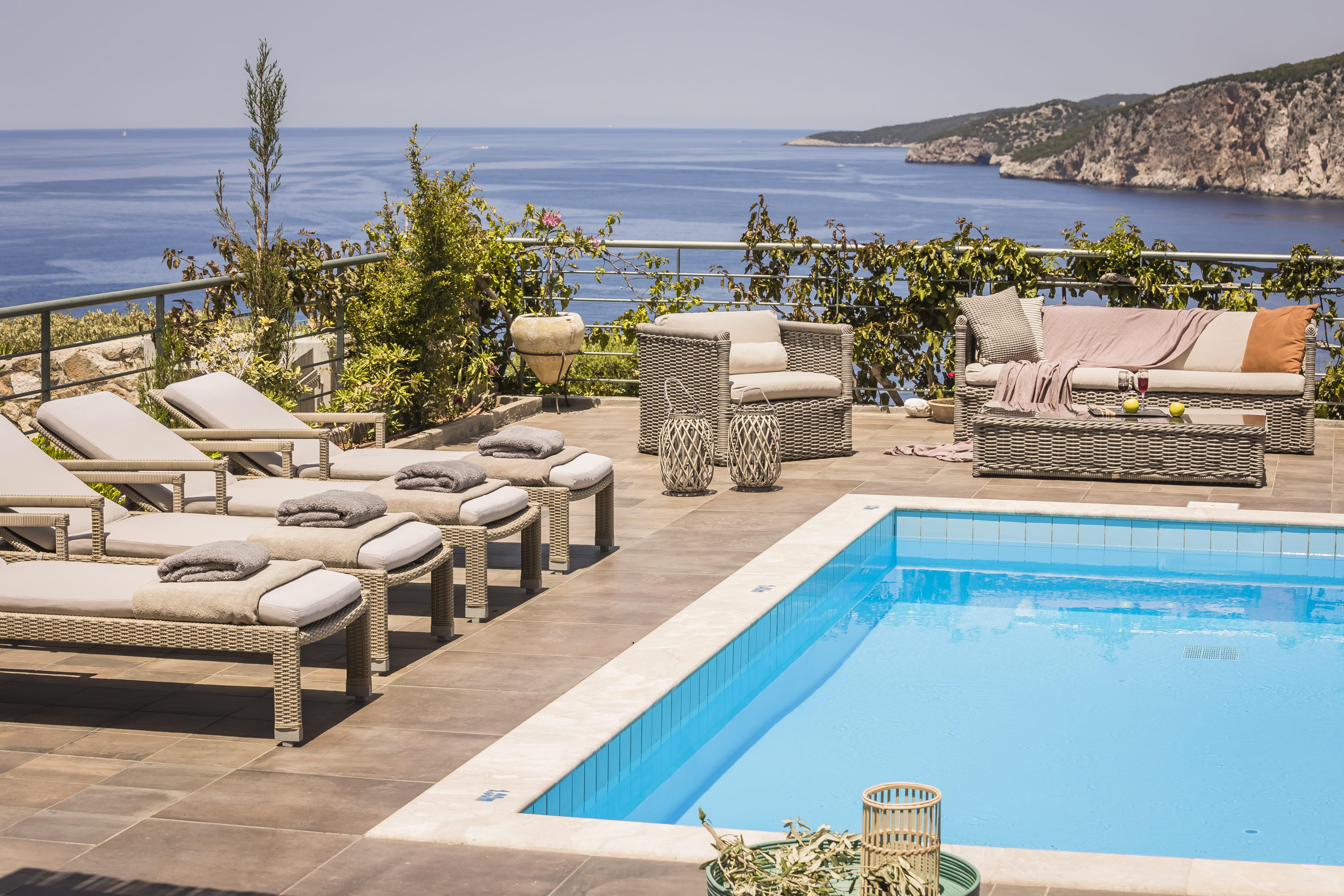 a pool with lounge chairs and a view of the ocean