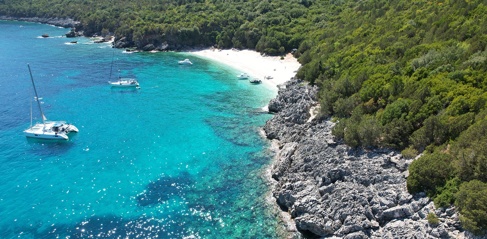a beach with blue water and boats