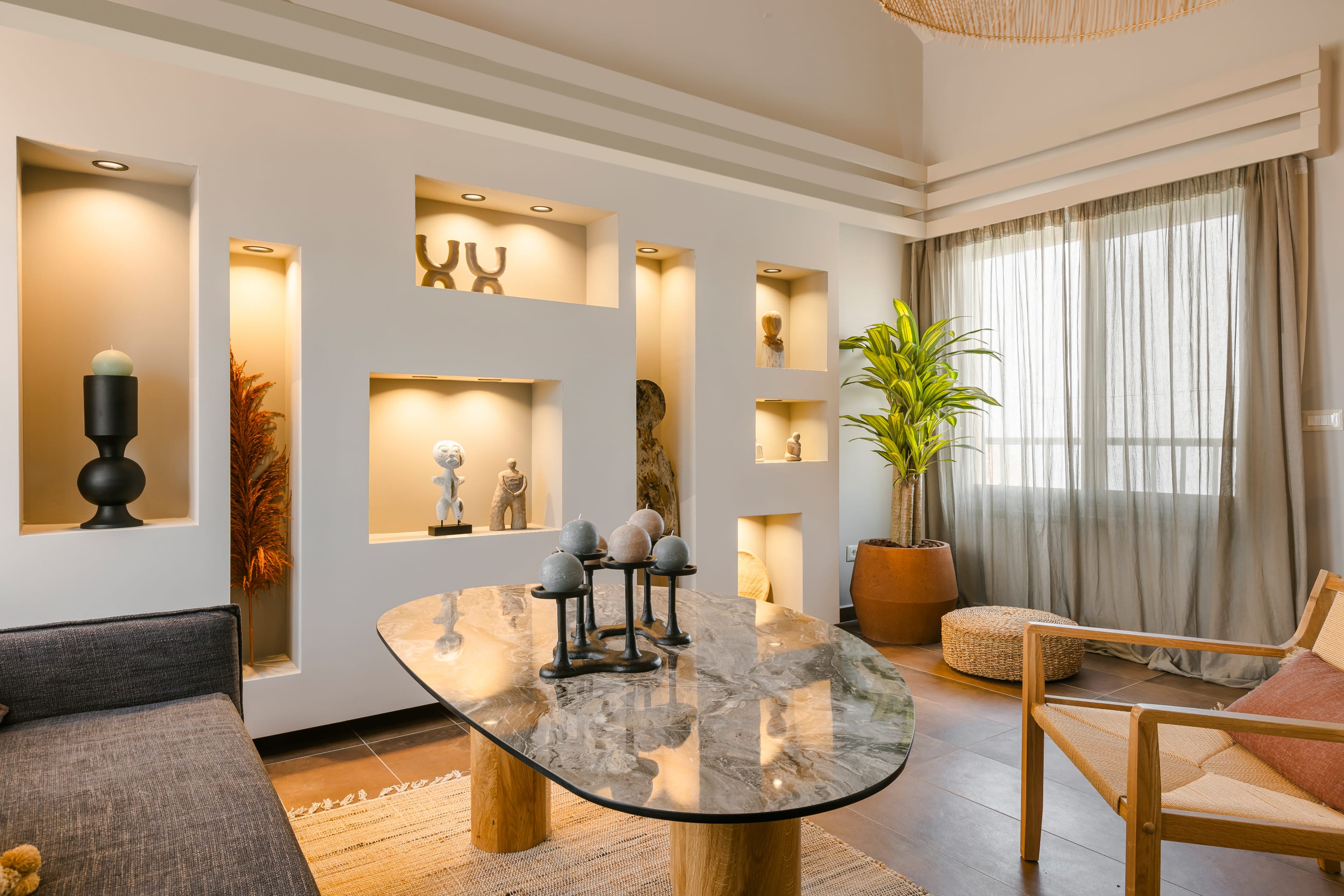 a living room with a glass coffee table and a large mirror