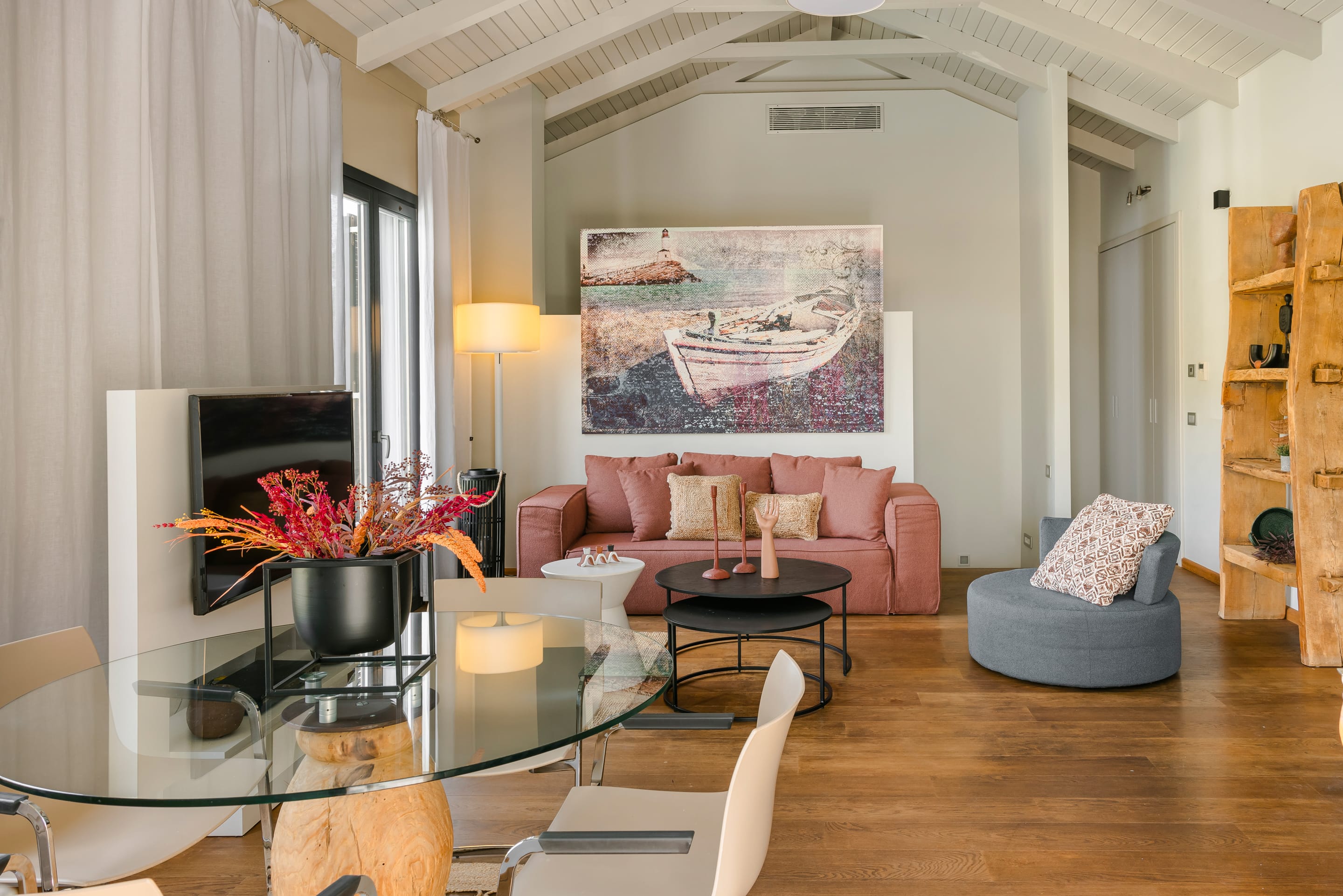 a living room with a glass coffee table and a television