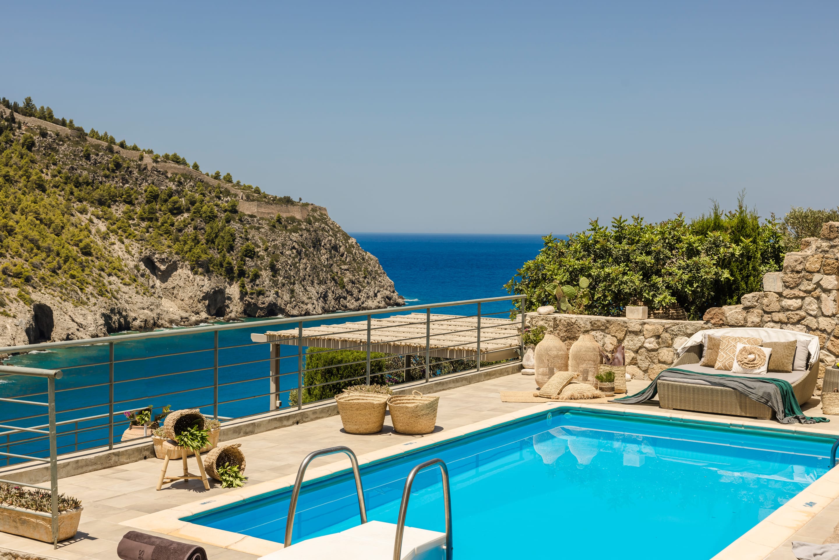 a pool with a deck and a hill with a body of water