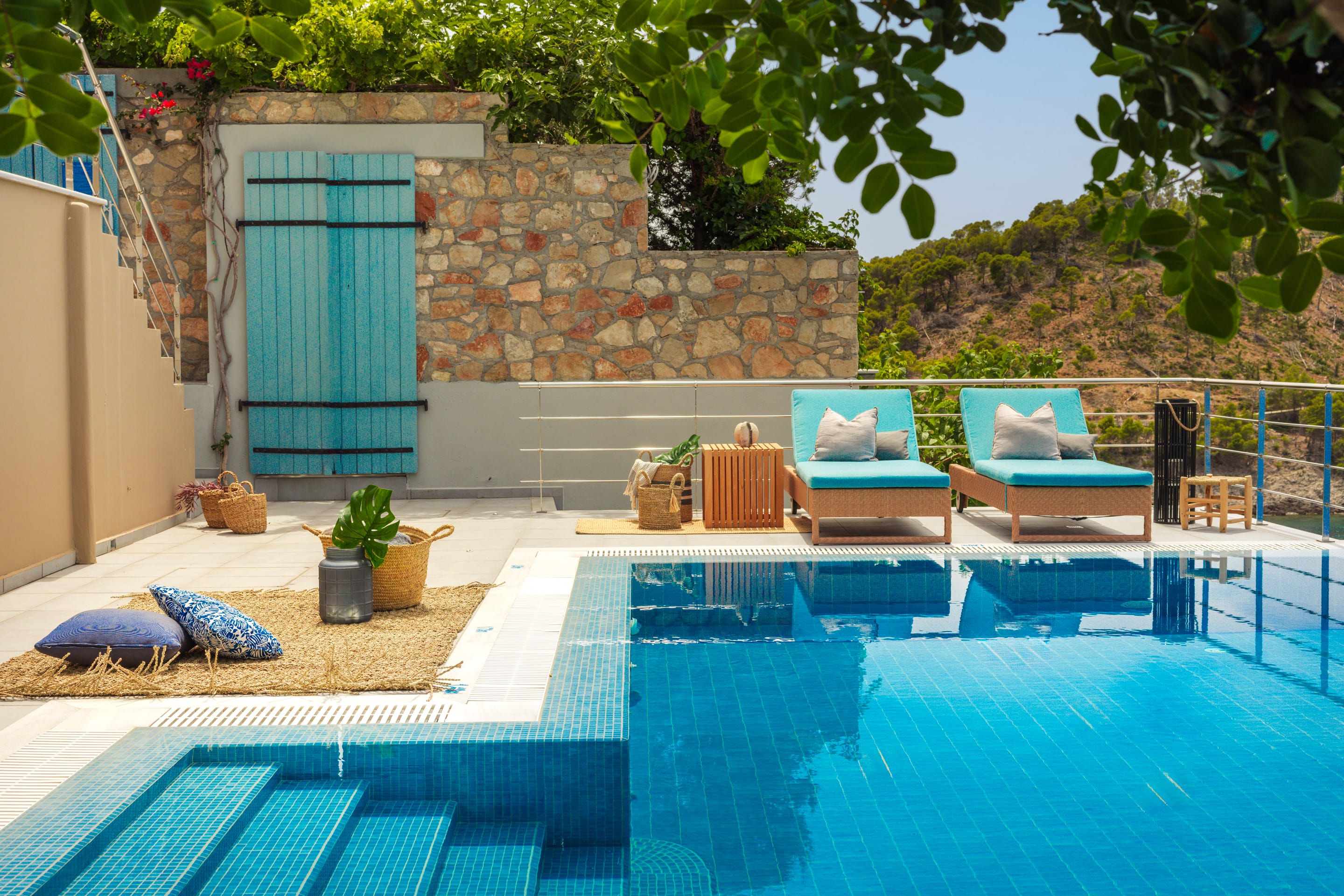 a pool with chairs and a person lying on the ground by it