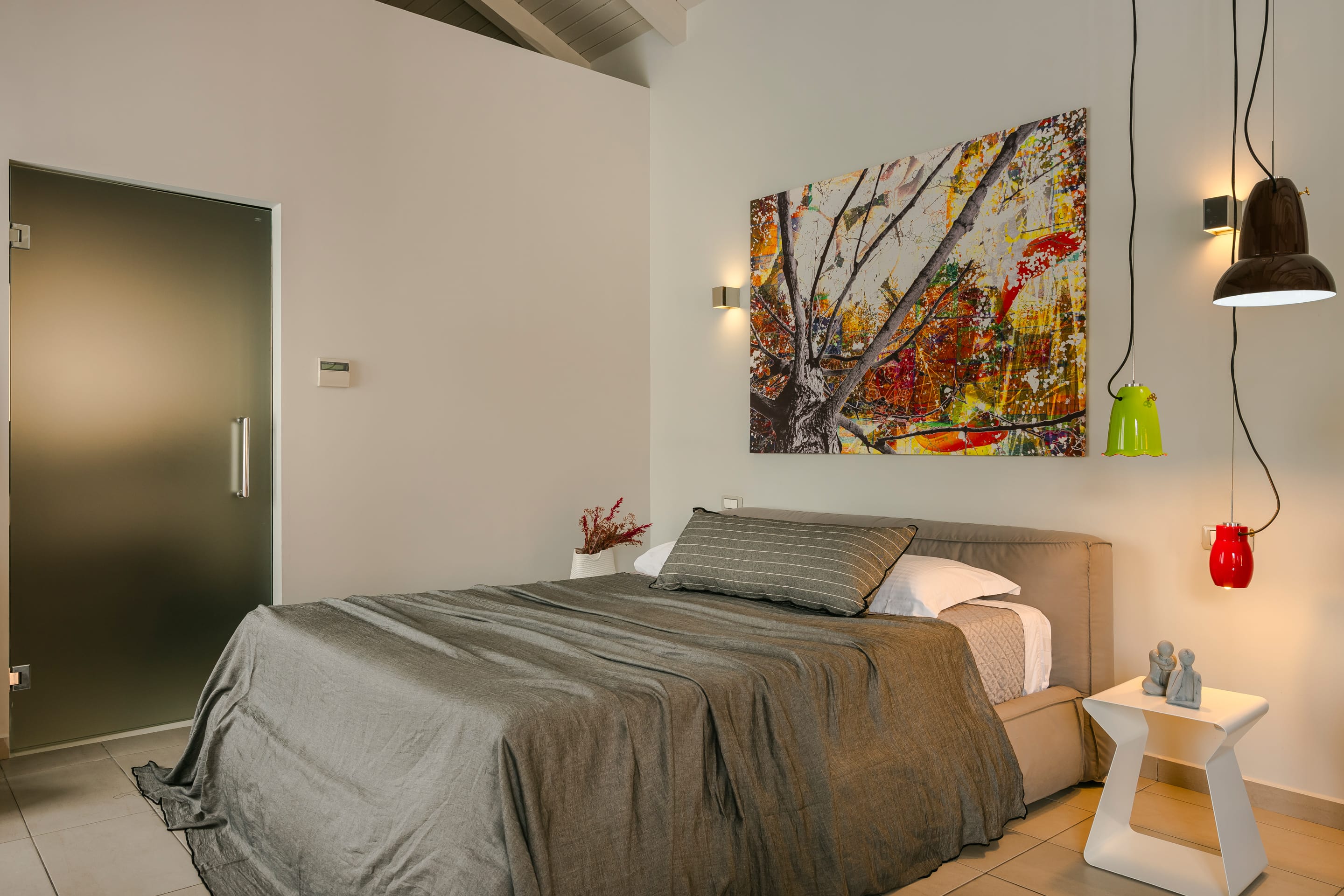 a bedroom with a painting on the wall