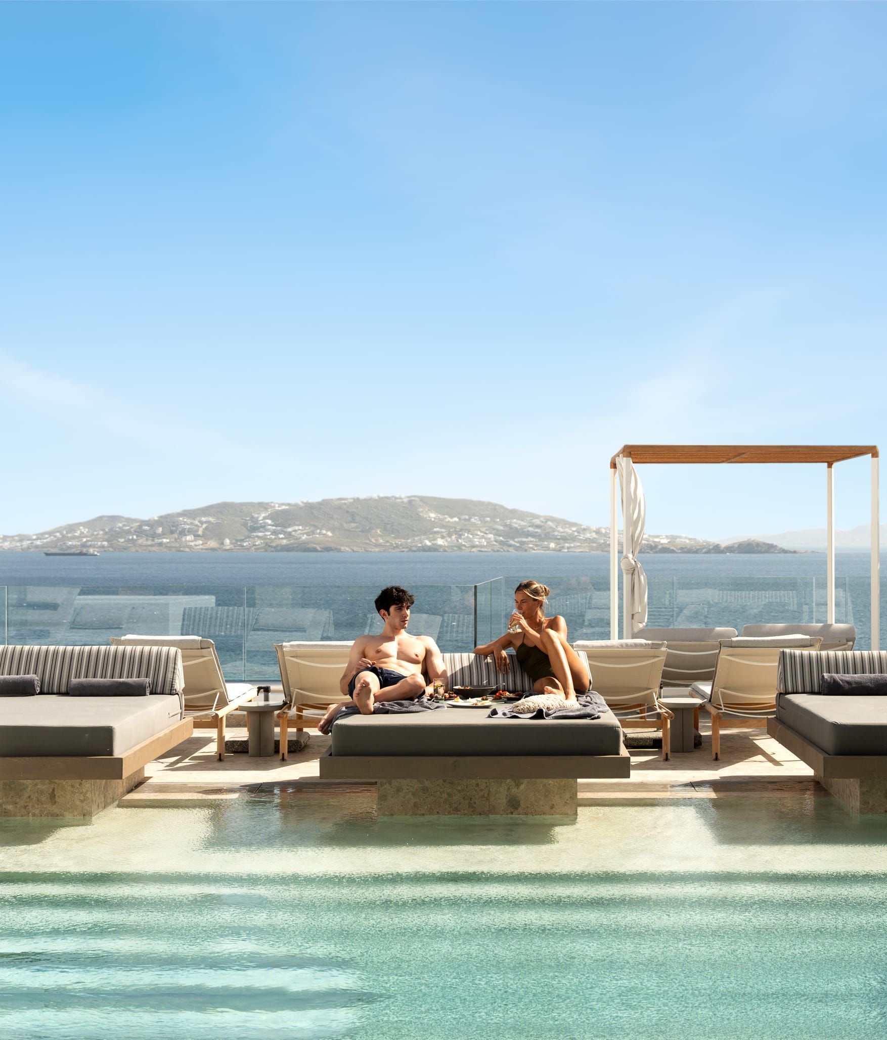 a couple sitting on a pool deck