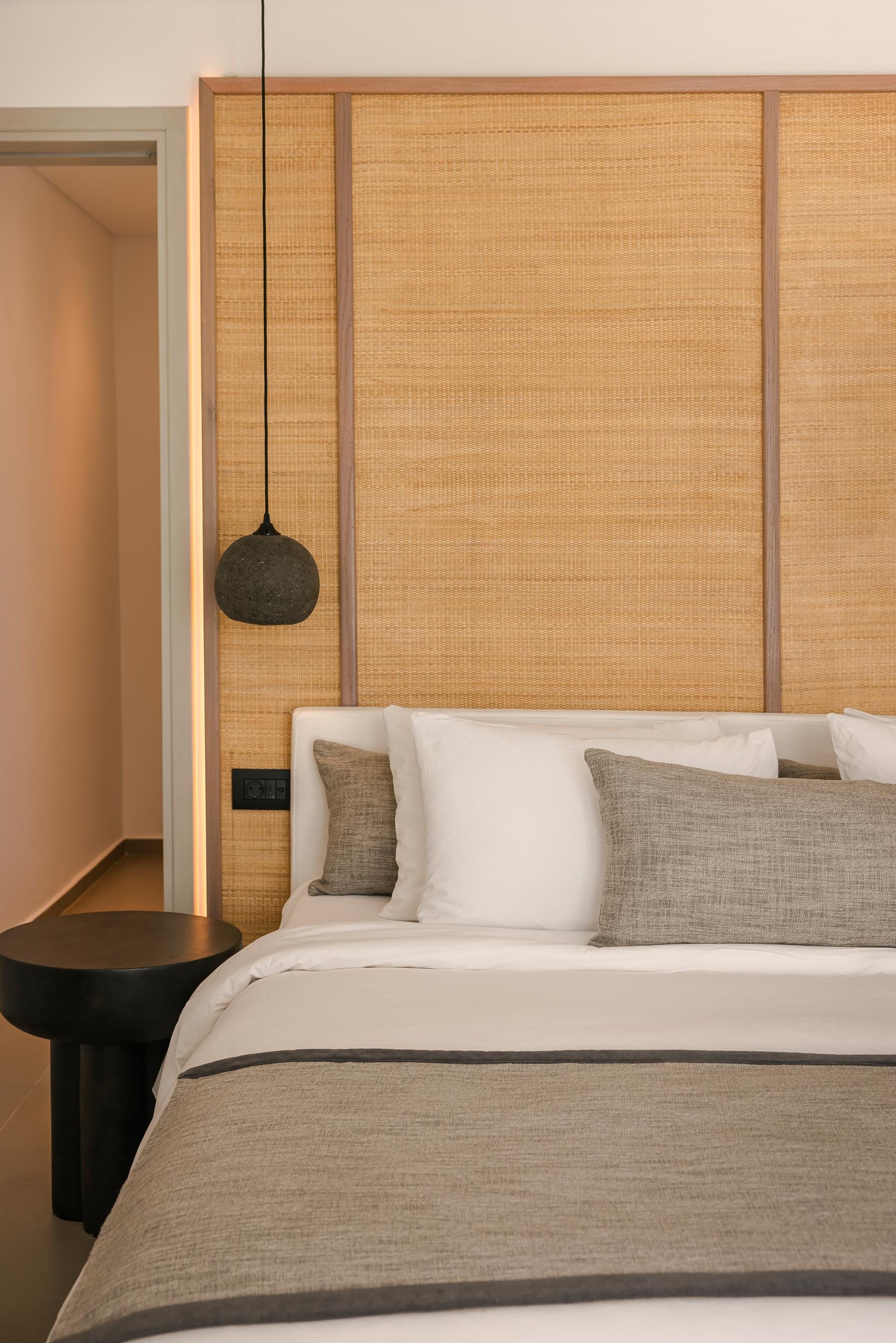 a bed with a lamp on the wall