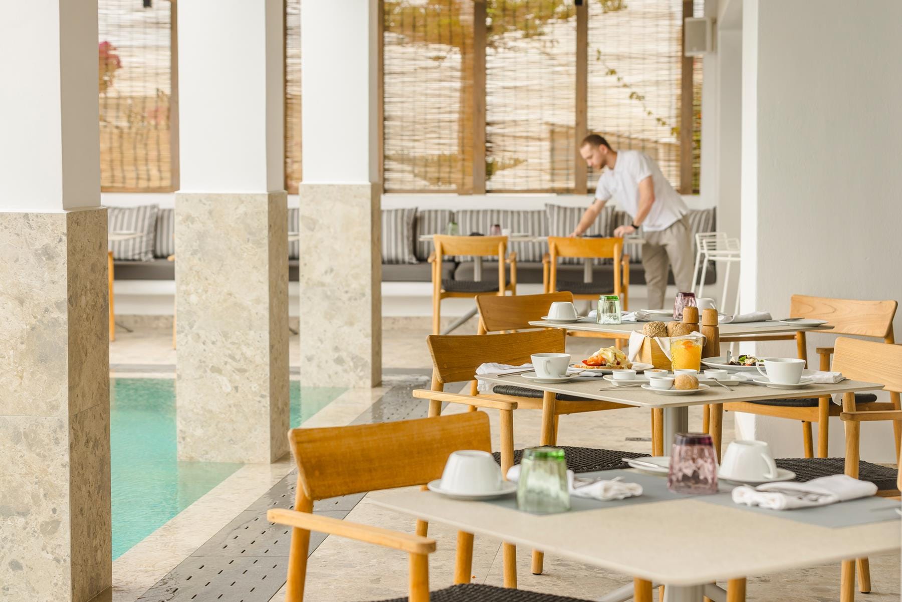 a person standing in a room with tables and chairs
