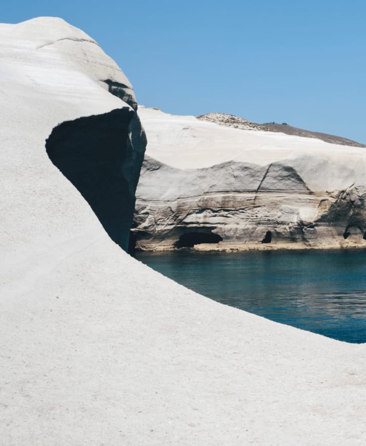 a body of water with ice and snow on the side