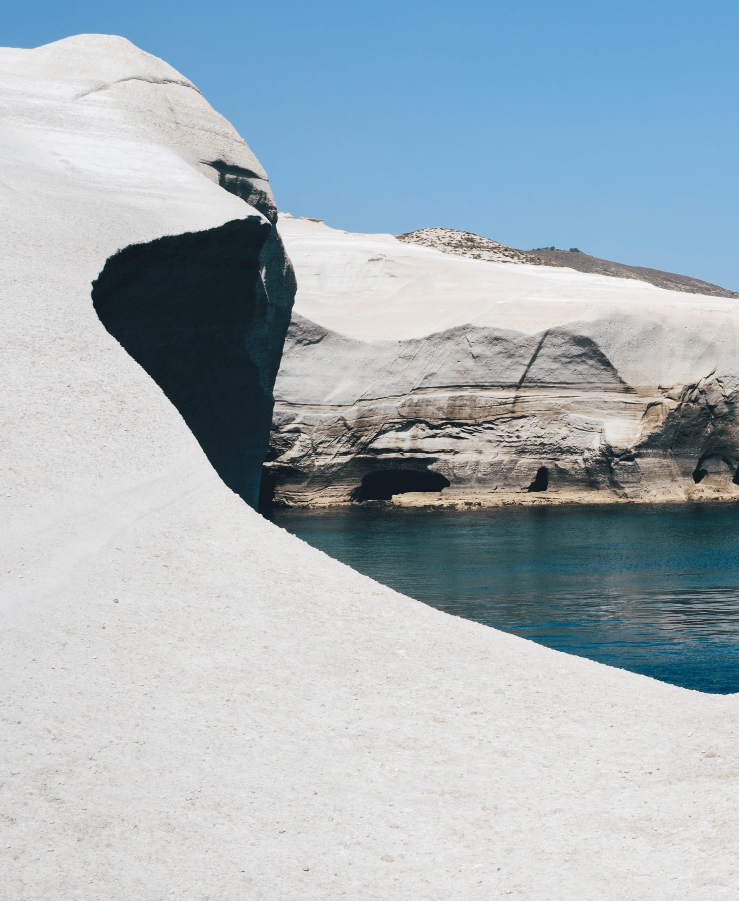 a body of water with ice and snow on the side