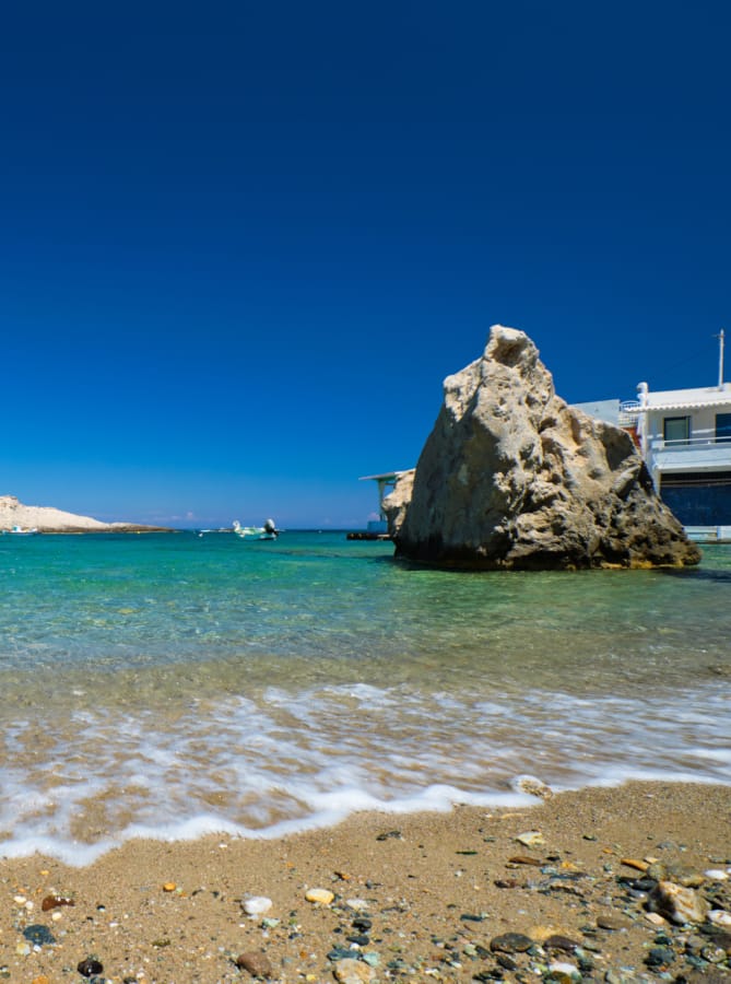 a rocky beach with a large rock in the water
