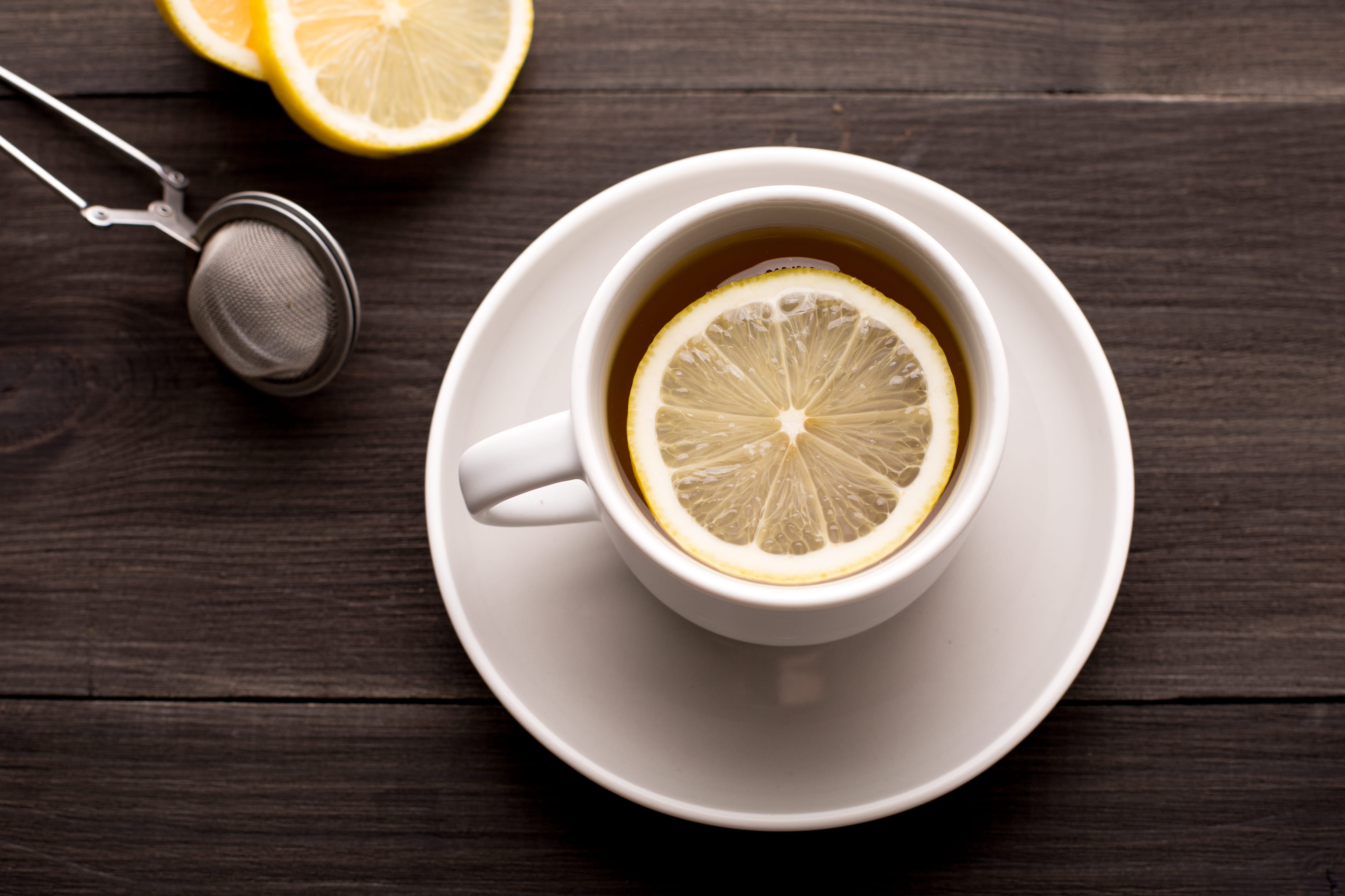 a cup of coffee with a slice of lemon on the rim