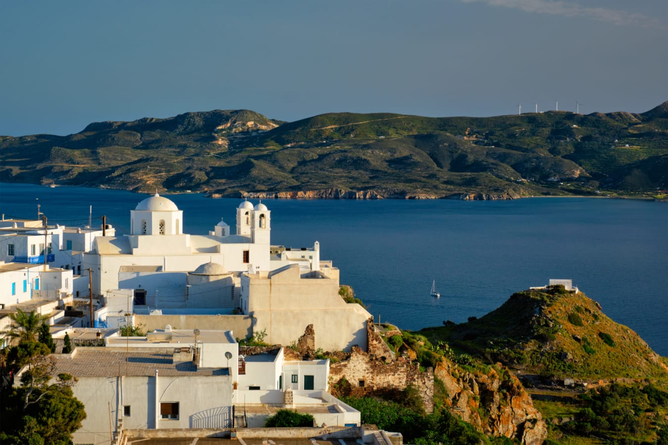 a white building on a hill by a body of water