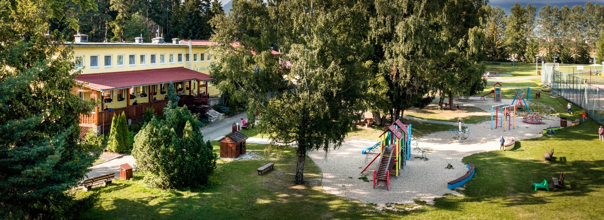 a building with a pool and trees around it