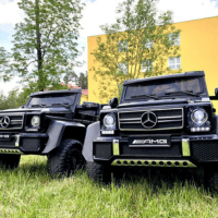 a couple of black trucks parked in a grassy field