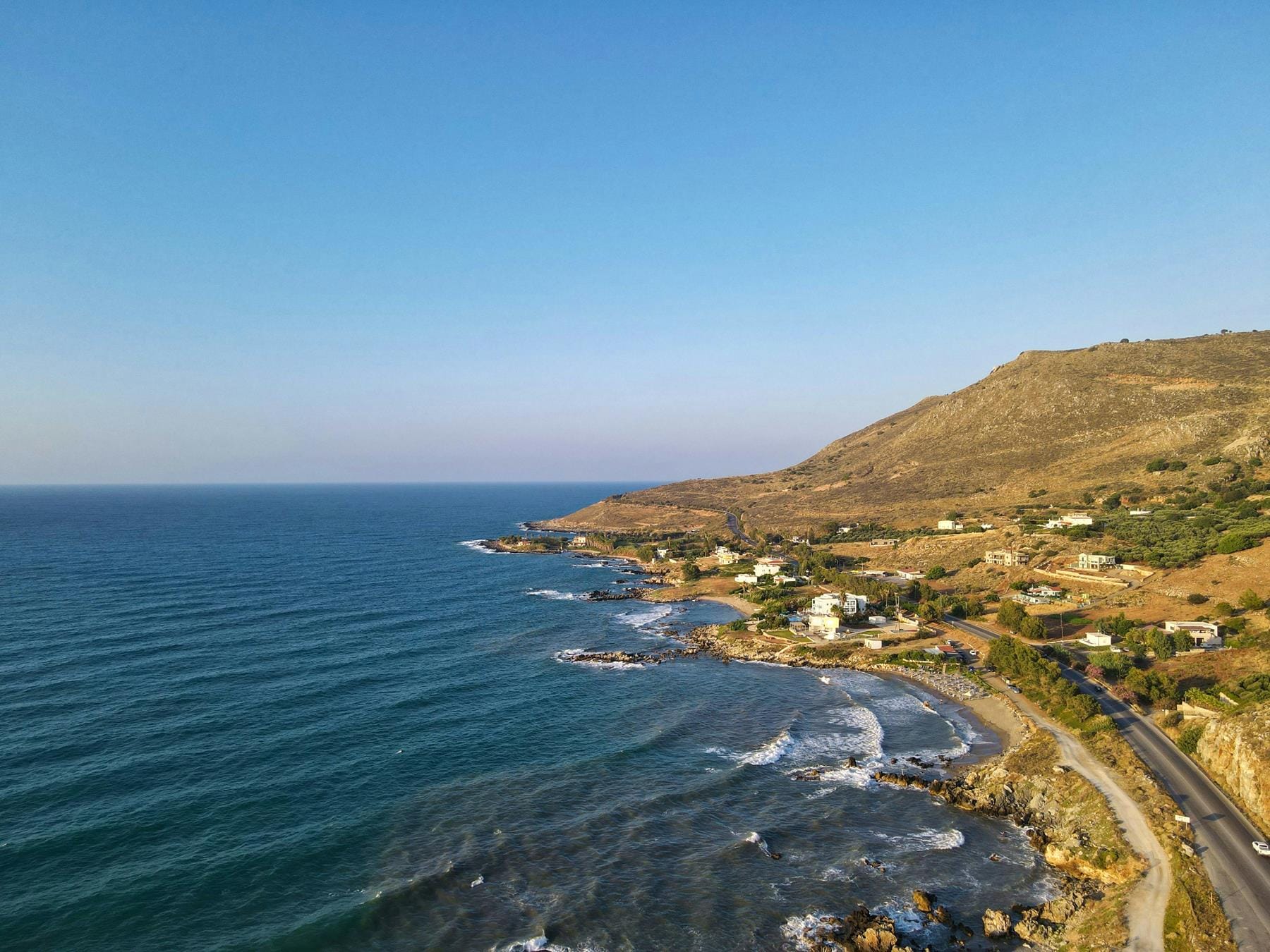 a beach with a road and water