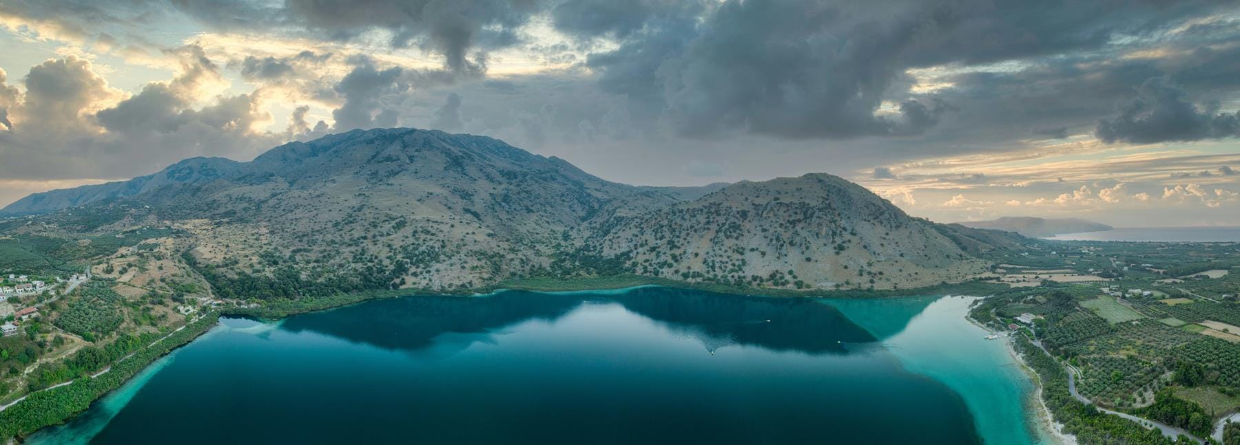 a large body of water with a mountain in the background
