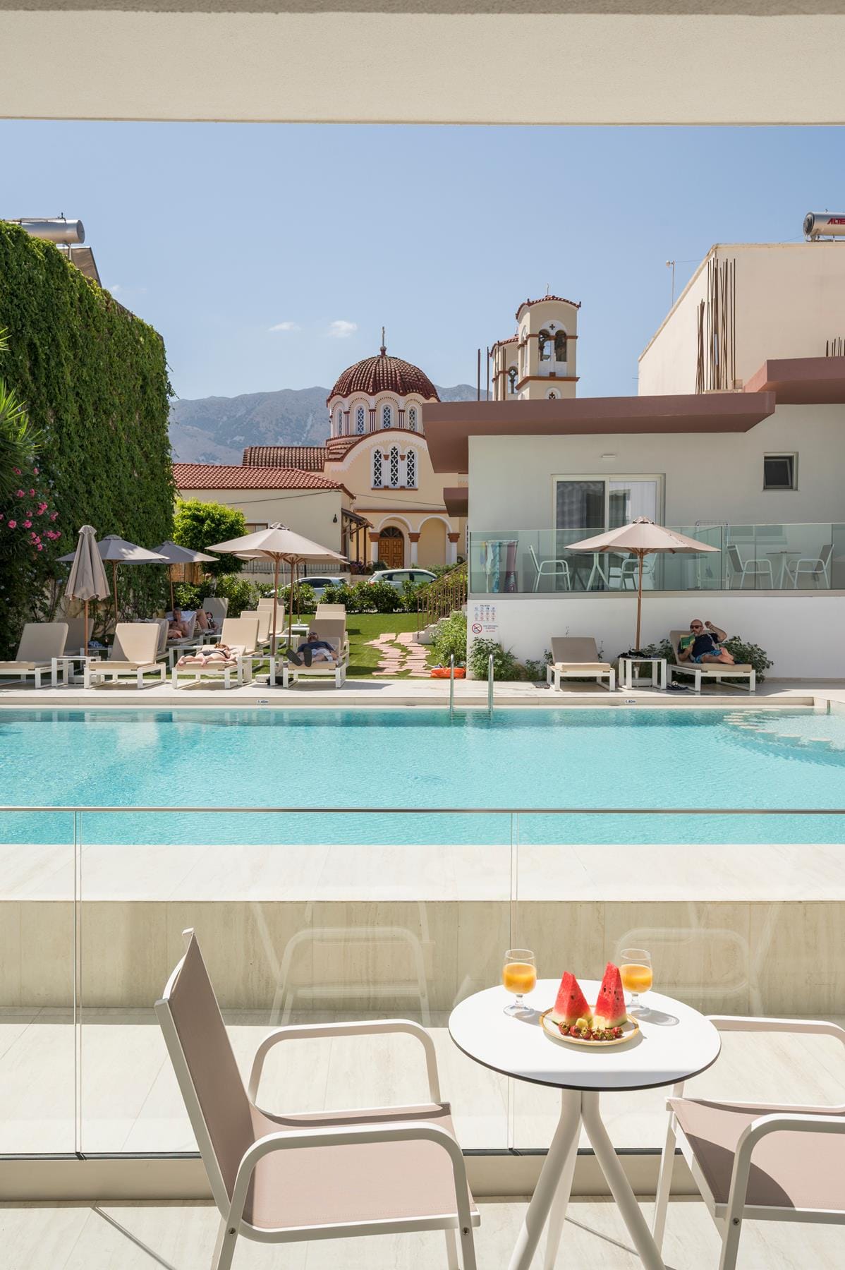 a pool with chairs and tables next to it
