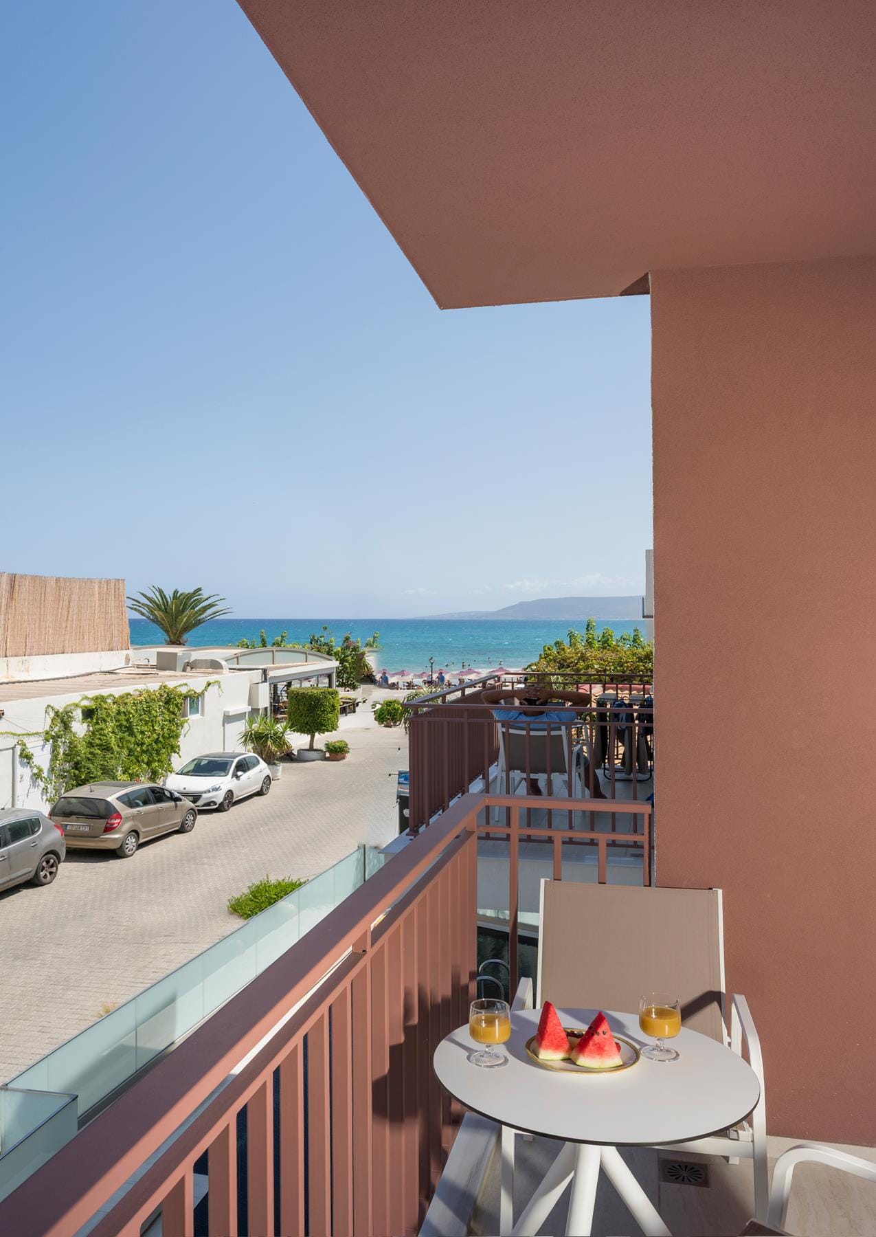 a patio with a table and chairs and a body of water in the background