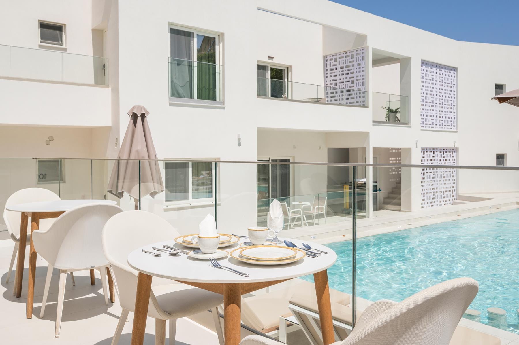 a table and chairs next to a pool