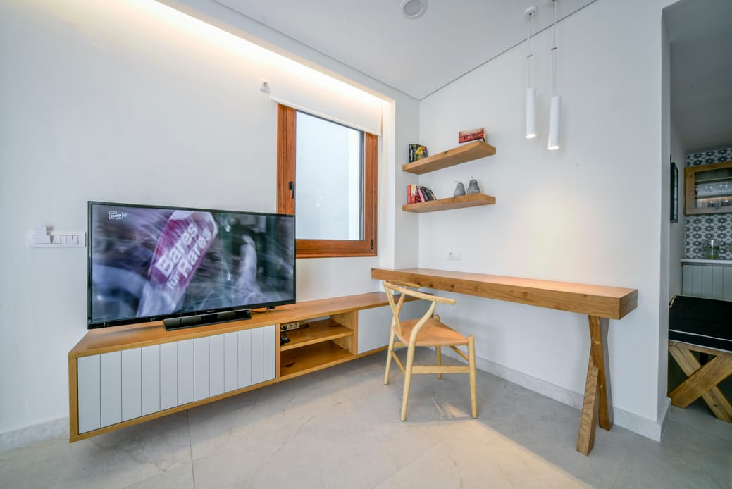 a room with a tv and shelves