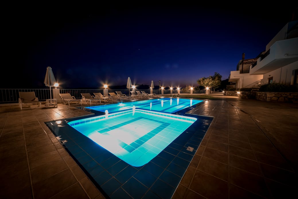 a pool with a deck and a building in the background